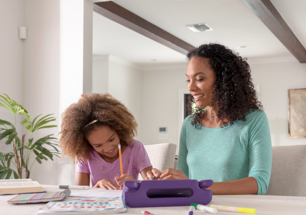 A mother and daughter enjoying creative drawing time together at home.